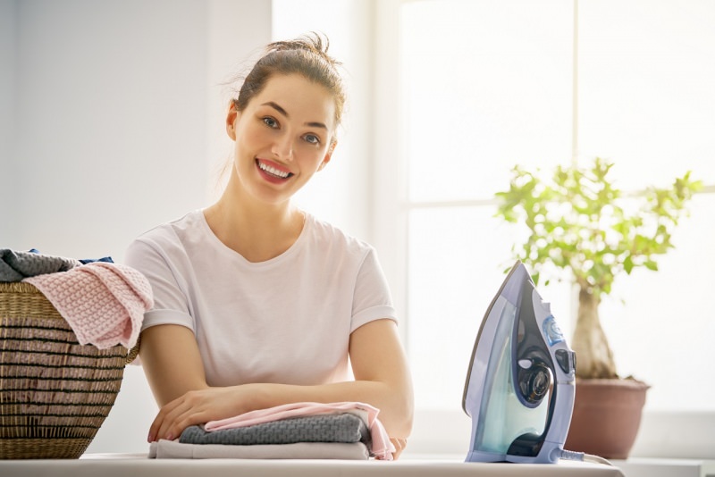 stirare facile bella donna sorrifente panni stirati cesta ferro dastiro asse casa