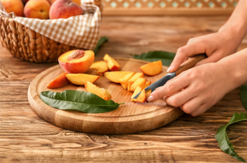 tagliere legno pesche coltello pezzi di pesca preparazione granita