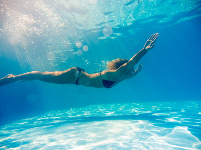 bella donna fisico atletico nuota in piscina acqua azzurra
