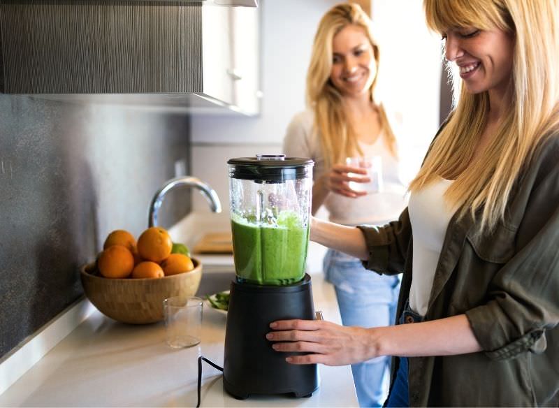 donne amiche preparano succo detox con frullatore