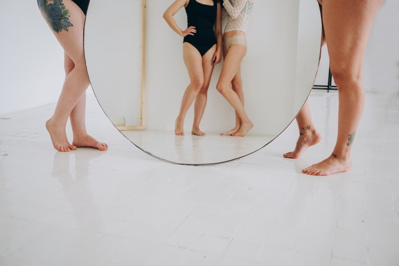 donne viste allo specchio diverse taglie gambe