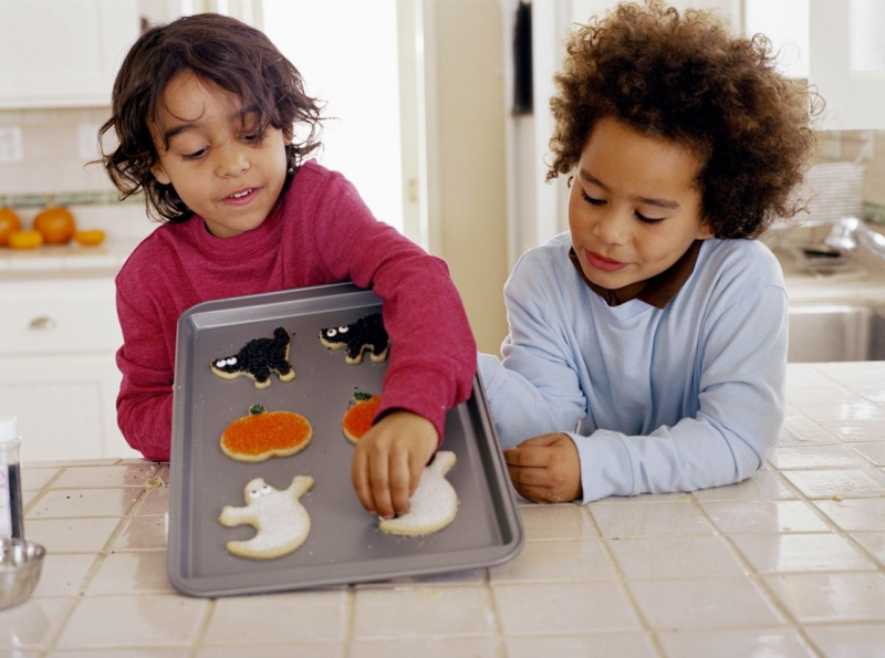 bambini prendo biscotto di Halloween dalla teglia