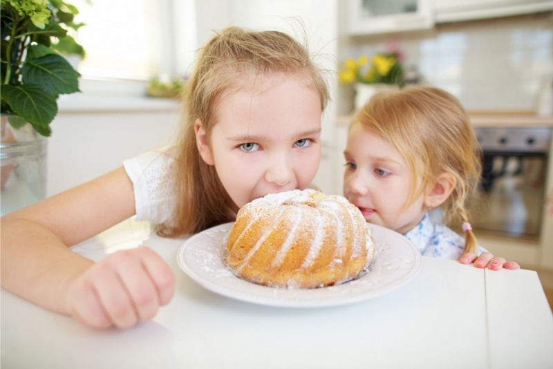 bllissime bambine capelli biondi occhi azzurri mordono ciambellone zucchero a velo