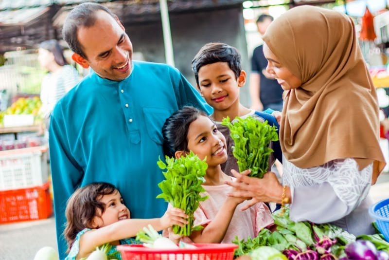 famiglia felice al mercato figlie bambine scelgono verdure