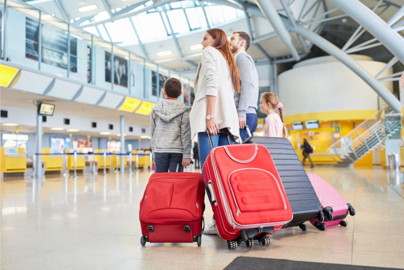 bambino figlio trasporta trolley rosso su ruote bambina figlia treccia trolley rosa mamma pap valigia nero aeroporto partenze