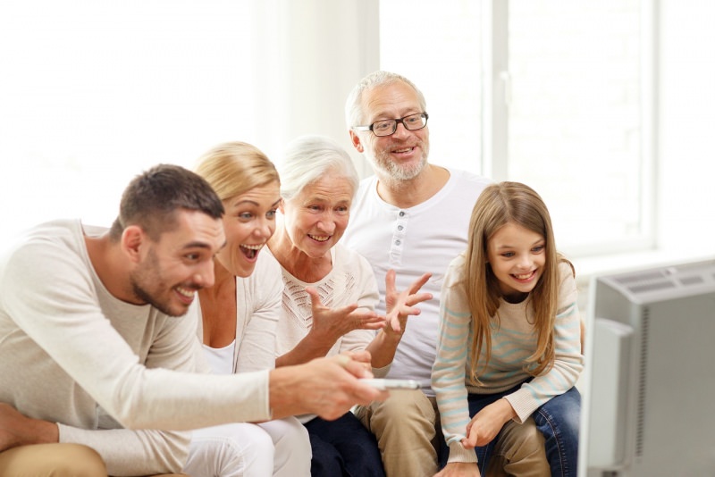 famiglia felice guarda la televisione insieme a casa