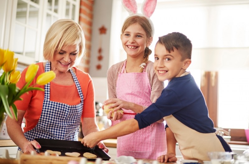 mamma e figli cucinano insieme felici periodo di Pasqua biscotti