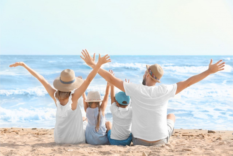 donna mamma bambina figlia con trecce bambino figlio uomo papà cappello paglia t-shirt bianca onde mare sabbia estate vacanza