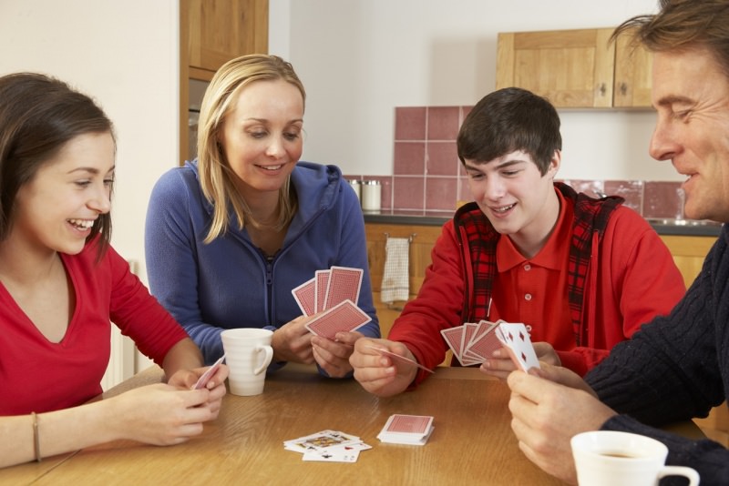 famiglia gioca a carte in cucina a casa sorrisi