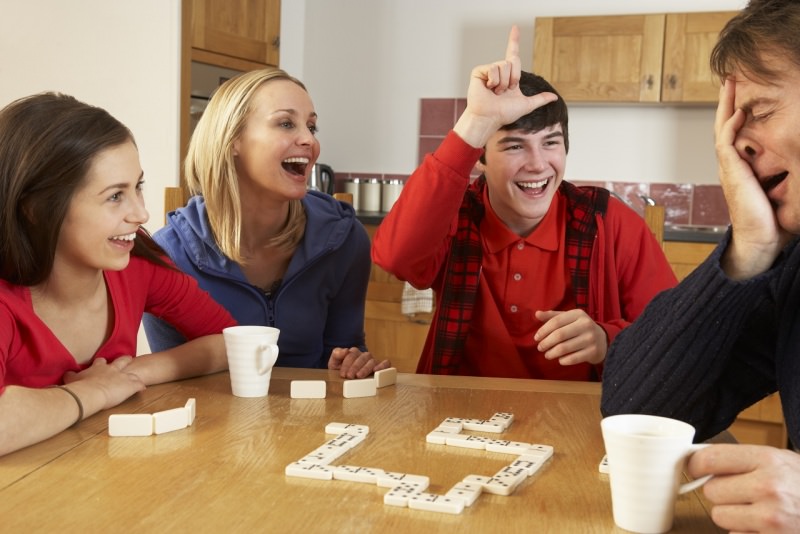 famiglia gioca a domino in cucina a casa