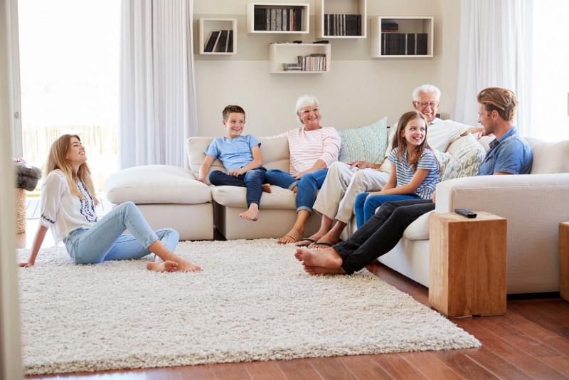 famiglia felice in soggiorno seduta sul divano sorrisi stare insieme a casa