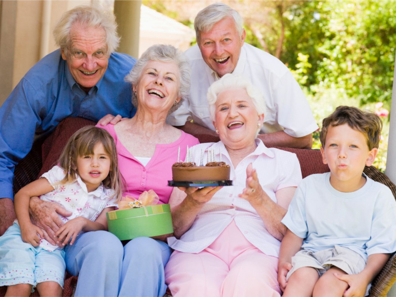 nonno nonna uomo donna anziani festeggiati dai nipotini torta festa dei nonni 2 ottobre