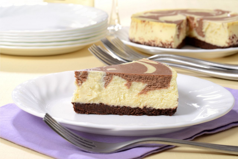 cheesecake al cioccolato servita su piatto ceramica bianca tavola apparecchiata