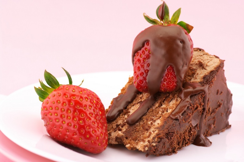 fetta di torta al cioccolato con fragola fresca ricoperta di ganache