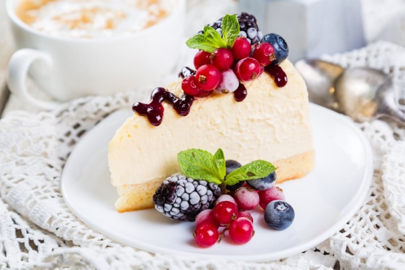 fetta di torta allo yogurt frutta di bosco tazza di te foglie di menta