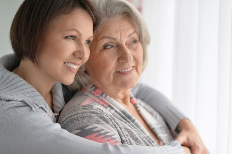 donna figlia adulta abbraccio mamma anziana sorrisi