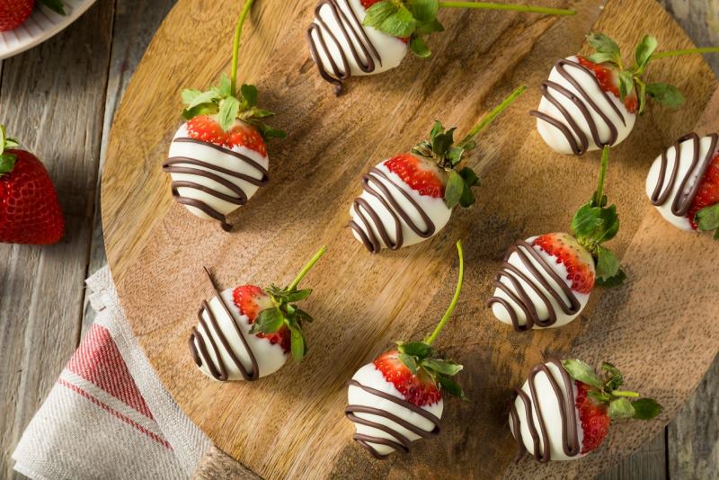 fragole ricoperte con cioccolato bianco e decoro con strisce fondente