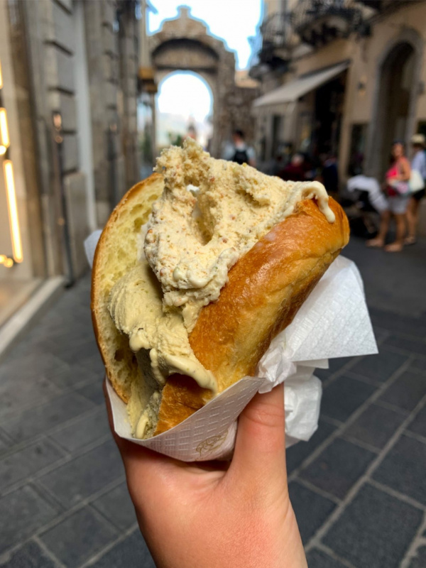 brioscia siciliana brioche con gelato in mano a una donna in strada