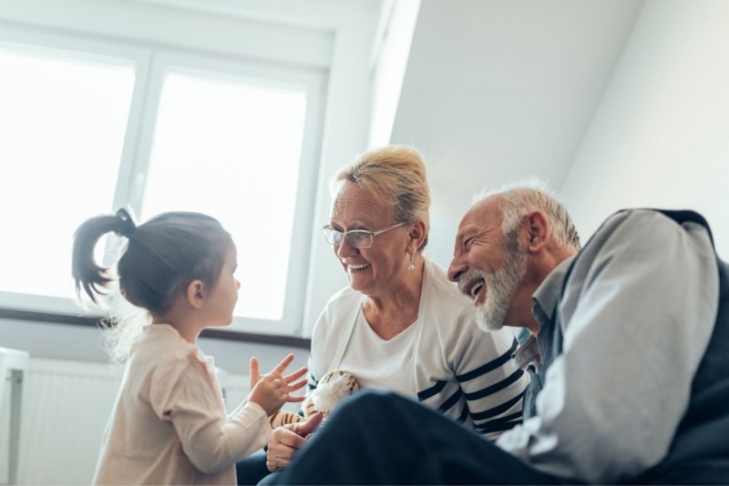 nonni sorridento ascoltano la nipotina loro gioia