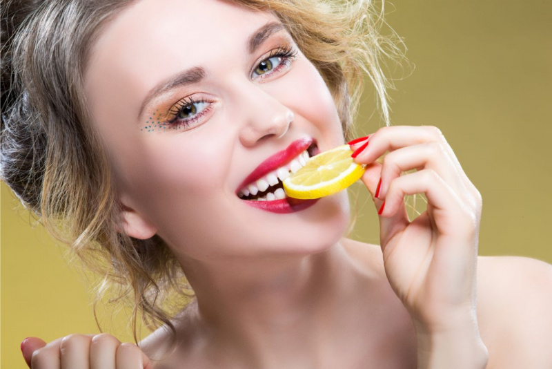 donna occhi verdi rossetto rosso denti bianchi fetta limone