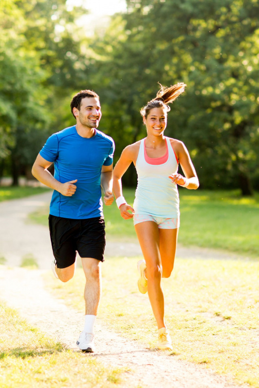 uomo sorridente corre insieme a donna allenamento parco natura