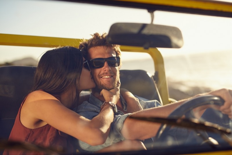 giovane coppia bacio viaggio auto sorriso