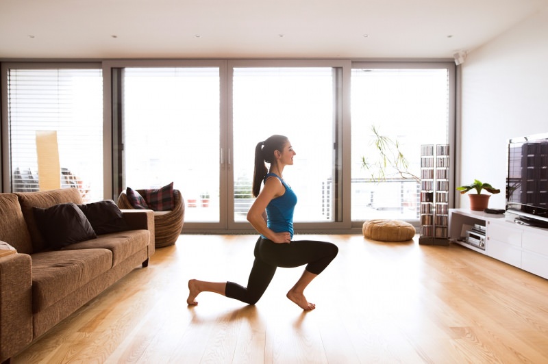 donna fa esercizi fisici fitness in casa soggiorno