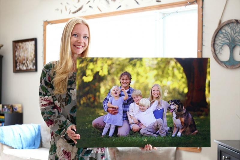 bella donna bionda occhi azzurri tiene orgogliosa foto famiglia all'aperto stampa su tela soggiorno