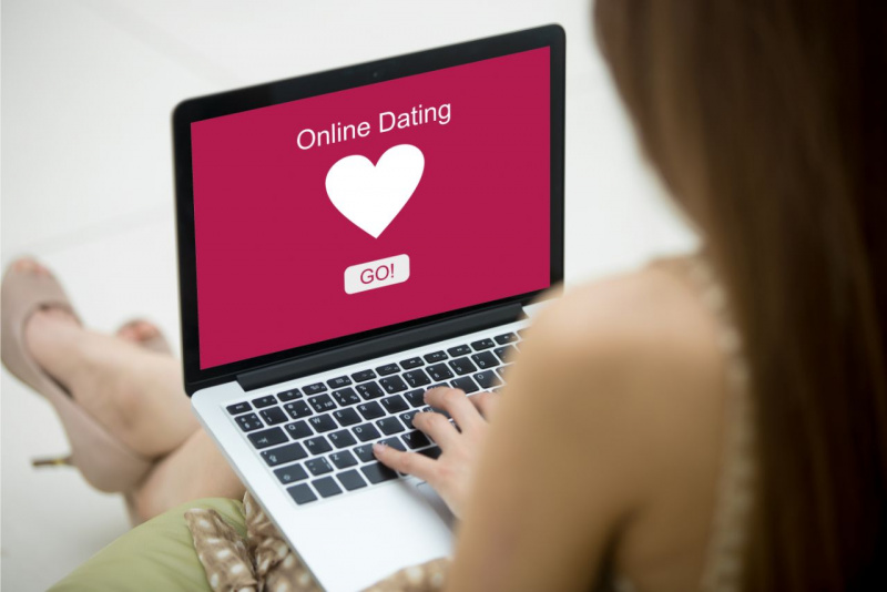 corteggiare su internet schermo laptop rosa fucsia cuore bianco online dating concetto