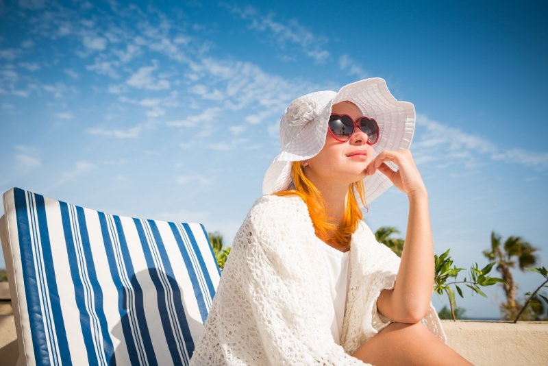 giovane bella donna capelli rossi tipo celtico fototipo 1 cappello occhiali da sole protezione solare