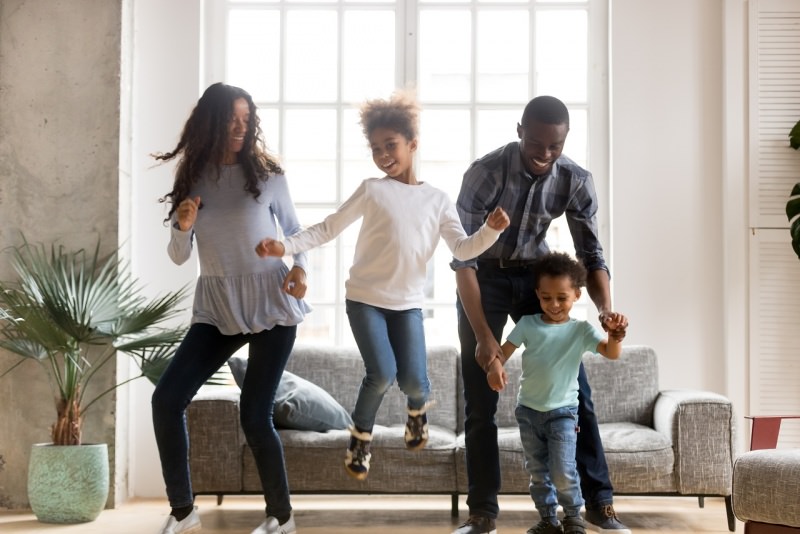 famiglia felice allegra sorridente balla salotto di casa