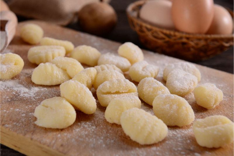 tagliere di legno con gnocchi di patate freschi fatti a mano farina