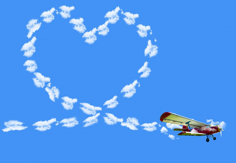 aereo crea cuore con scie di condensazione nuvole artificiali cielo azzurro