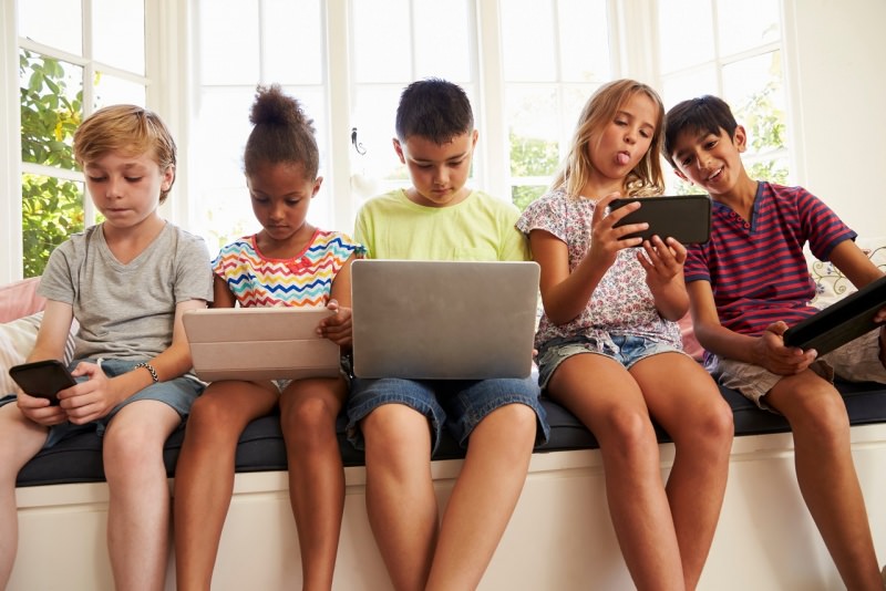 gruppo ragazzi seduti usano tablet laptop smartphone dispositivi digitali bambini