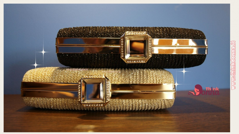 due borsette da sera pochette nera clutch oro glitter su tavolo legno