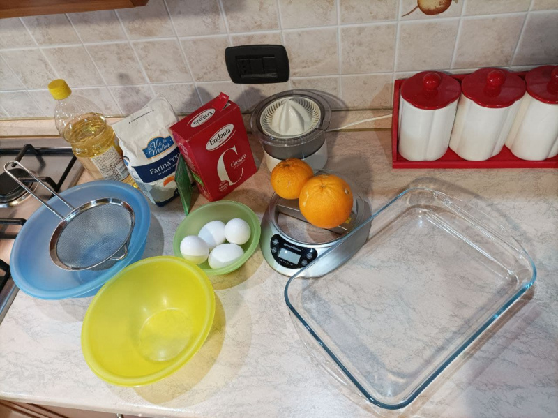 preparazione torta fatta in casa uova farina zucchero ciotole olio bilancia spremiagrumi colinolievito batattoli cucina