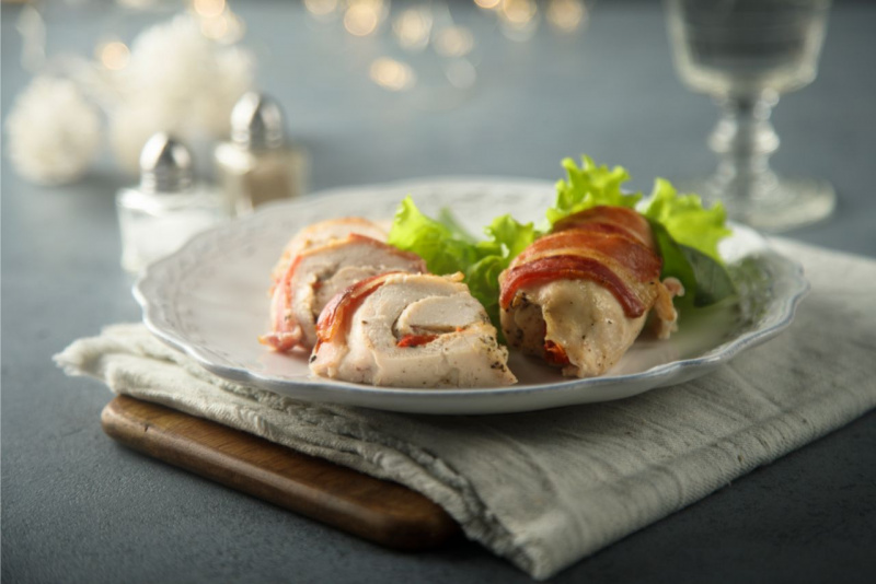 secondo piatto pronto in tavola involtini pollo speck tagliere legno saliera pepiera