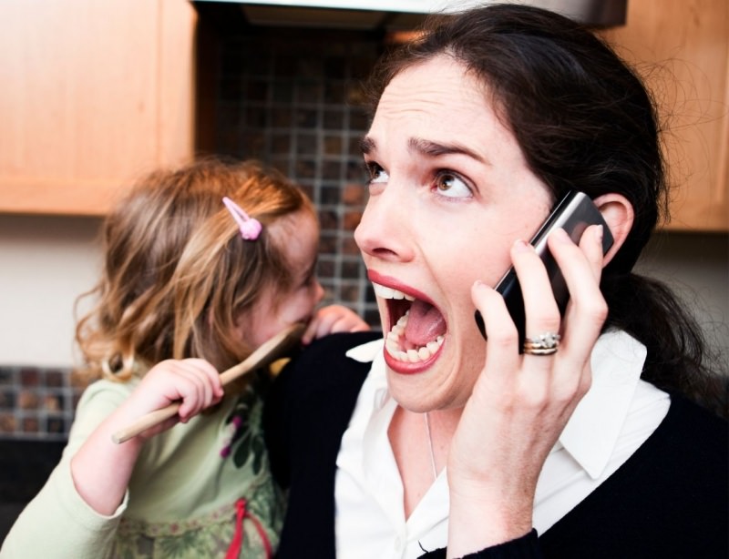 lavorare da casa con bamibni donna urla telefono stress bambina in braccio