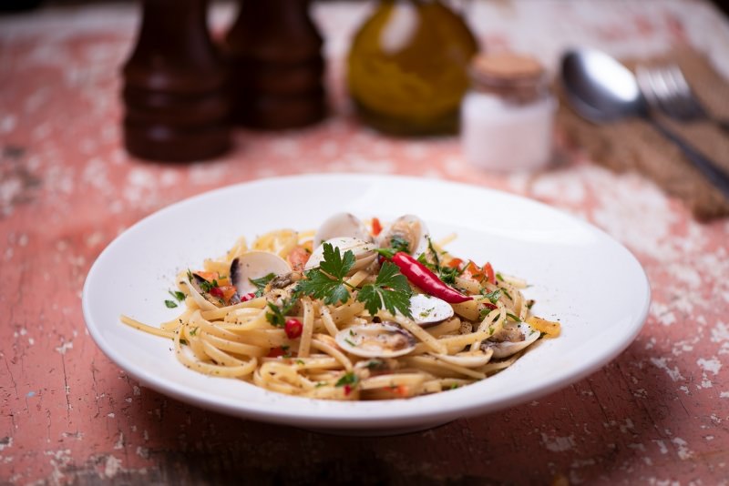 linguine al sugo di vongole e pomodorini piatto pronto in tavola apparecchiata macina sale e pepe