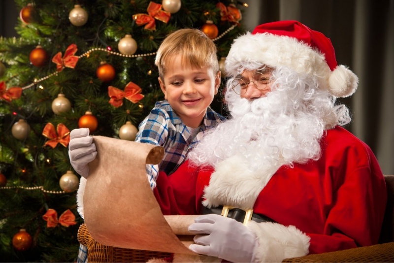 Babbo Natale e bambino leggono davanti Albero decorazioni spirito natalizio