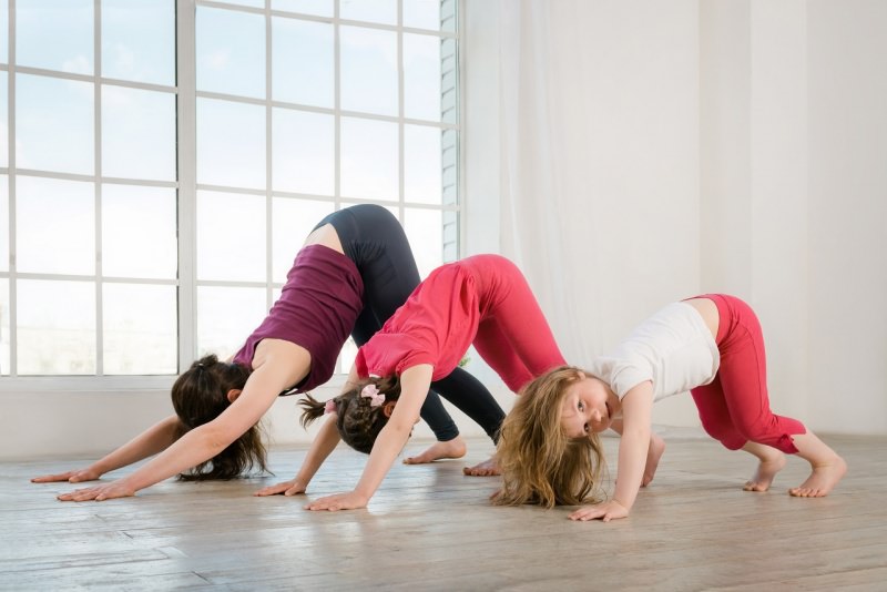 mamma e figlie fanno yoga in casa