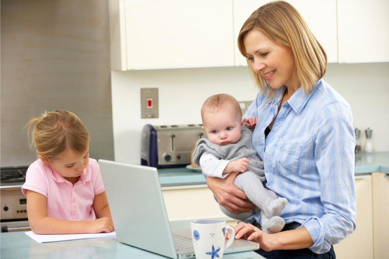 donna mamma bambino in braccio figli guarda laptop notebook