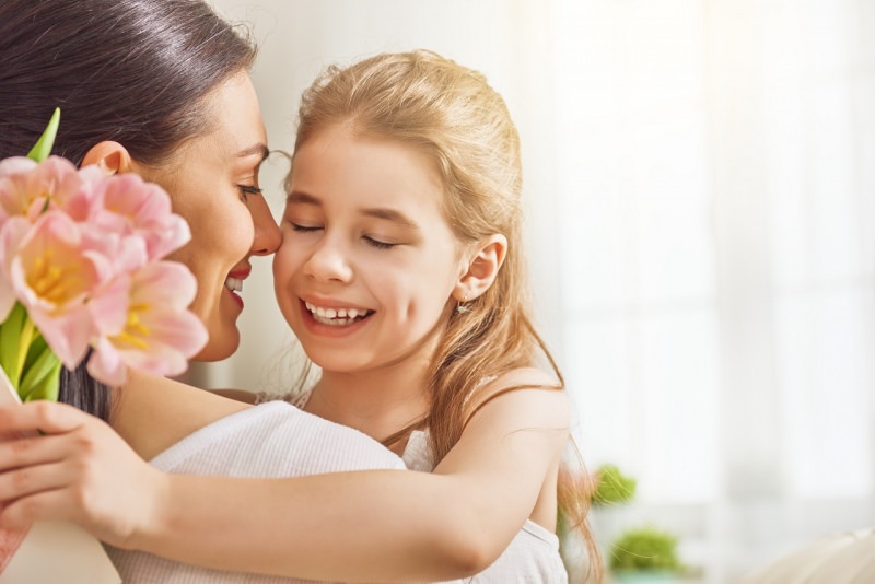 mamma e figlia bambina abbraccio sorrisi tulipani rosa festa della mamma