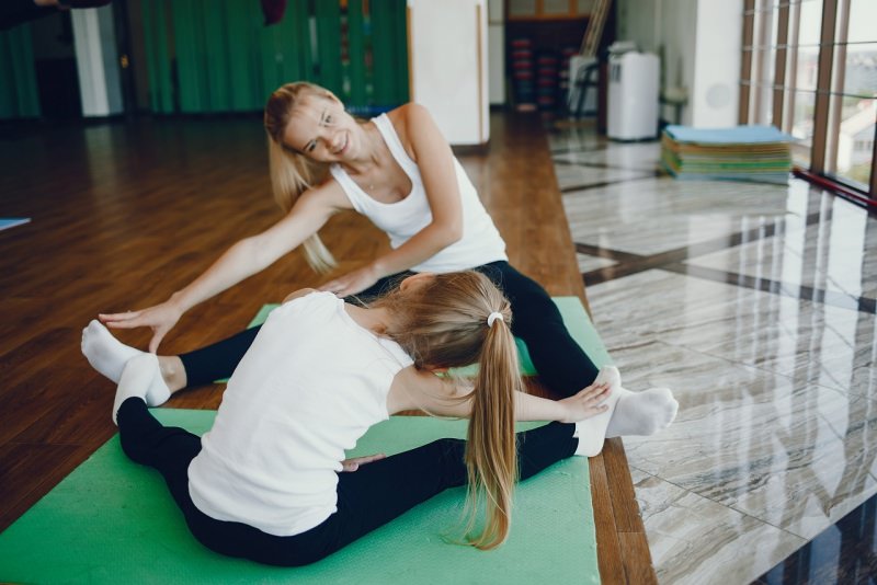 mamma e figlia fanno fitness in casa parquet soggiorno esercizi fisici