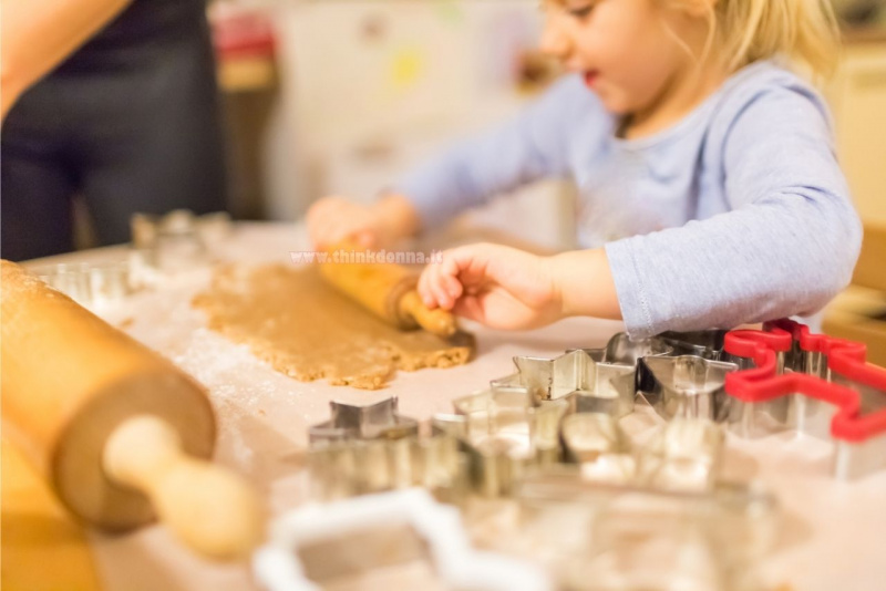 preparazione biscotti con bambini bella bambina usa mattarello pasta frolla formine stampi per biscotto