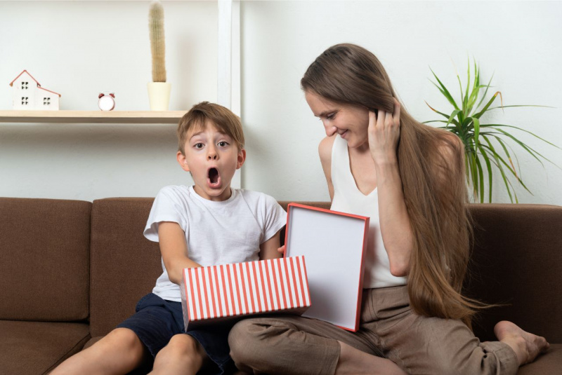 bambino espressione sorpreso per il regalo dalla mamma pacco divano