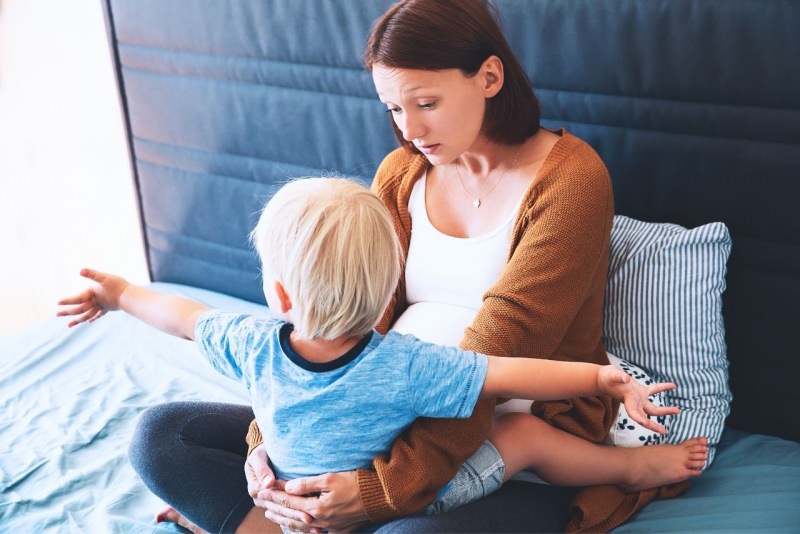 mamma incinta secondo figlio parla e tranquillizza primogenito abbraccio