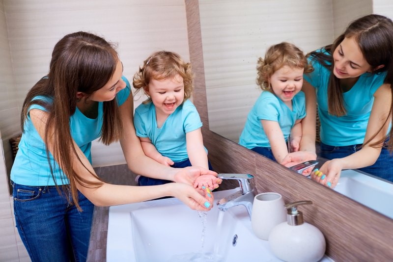 mamma e figlia specchio bagno giocano sorrisi lavarsi le mani