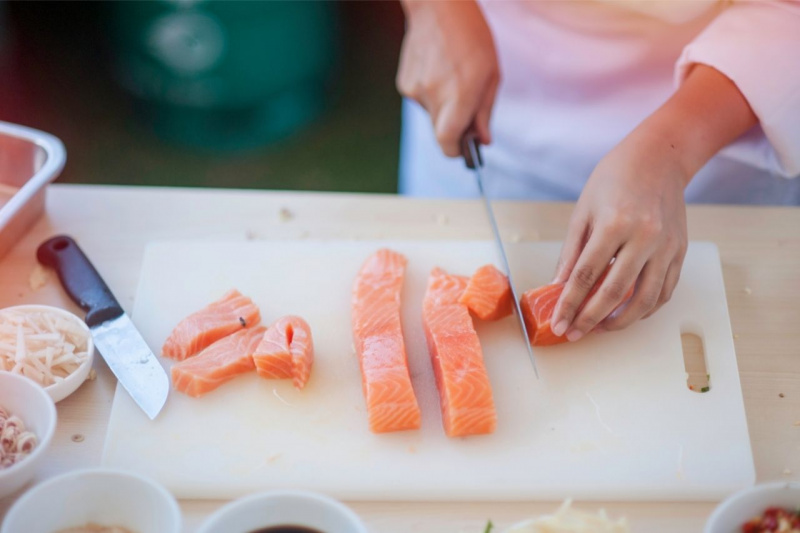 tagliere su tavlo pezzi salmone affumicato