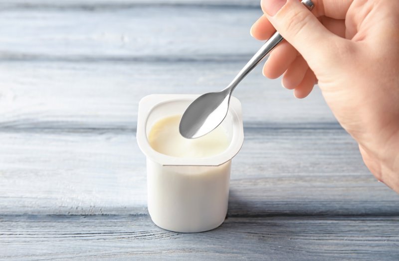 vasetto di yogurt mano donna cucchiaino